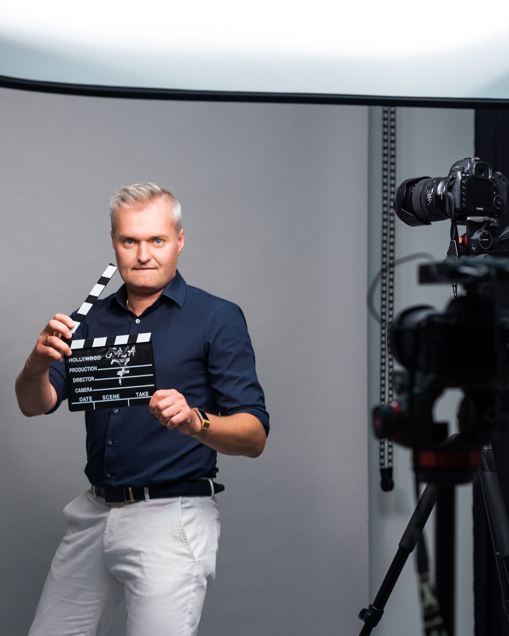 Vytautas Kontrimas holding a film clapperboard in a studio